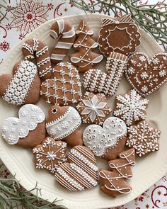 a white plate topped with lots of different kinds of gingerbread cut out in the shape of hearts