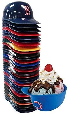 a large stack of plates with ice cream and chocolate toppings on them next to a blue bowl