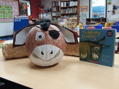 a pumpkin shaped like a cow sitting on top of a table next to a book