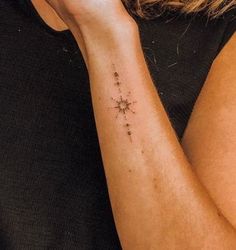 a woman's arm with a cross tattoo on it