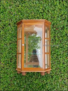 an old wooden lantern on top of a green wall