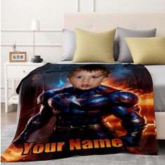 a bed with a blanket on it that has an image of a boy in the likeness of captain america