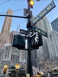 street signs and traffic lights on a pole in the city