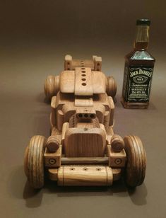 a wooden toy car next to a bottle of whiskey