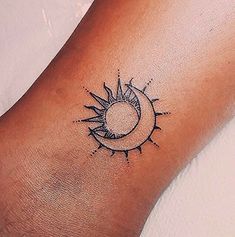 a small sun and moon tattoo on the wrist, done in black ink by an artist