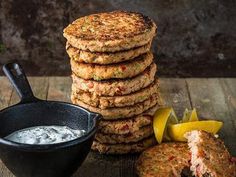 a stack of food sitting on top of a table next to a bowl of sauce