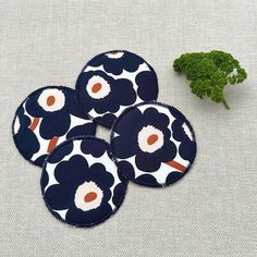 four coasters with flowers on them next to broccoli