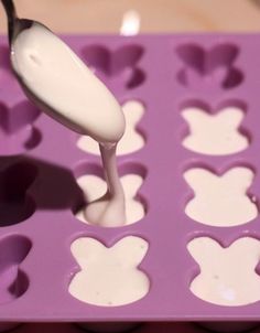 a spoon is in a mickey mouse shaped chocolate moulder with white icing