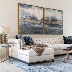 a living room with two paintings on the wall and a couch in front of it