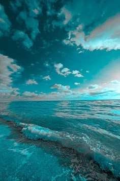 an ocean scene with blue and green colors in the sky, water and sand below