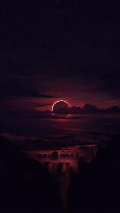 the eclipse is seen in the night sky over mountains and water, with an orange light shining