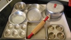 an assortment of cooking utensils and pans sitting on top of a stove