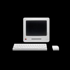 an apple computer with a keyboard and mouse on a black background in front of it