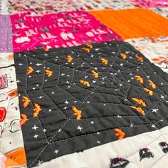 a close up of a quilt on a table top with many different colors and designs