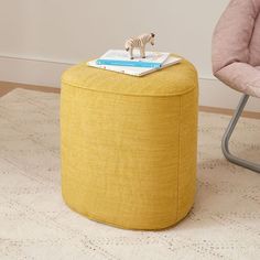 a small toy zebra on top of a yellow ottoman