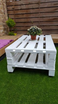 a white coffee table sitting on top of green grass