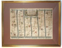 an old map hanging on the wall in a room with a brown frame and gold trim