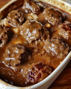 meatballs and gravy in a casserole dish on a wooden table