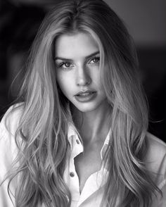 a woman with long blonde hair posing for a black and white photo wearing a shirt