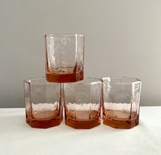 four glasses are sitting on a white surface