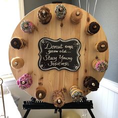 a wooden sign with donuts on it that says donut eve grow old stay young