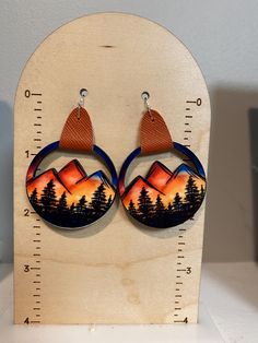 Look at these adorable earrings! These earrings are made using sublimation ink - no vinyl is used.  The mountain design is heat pressed on one side of the precut wood and is permanent.   The connector is made of faux leather. The earrings have an approximate 2.25" drop and are lightweight. The width is approximately 1.5"  Please allow for slight variances as each pair is made to order Please feel free to message me with any questions! Mountain Earrings, Mountain Design, Earrings Summer, Summer Earrings, Mountain Designs, Summer Earring, Sublimation Ink, Leather Earrings, Cute Earrings