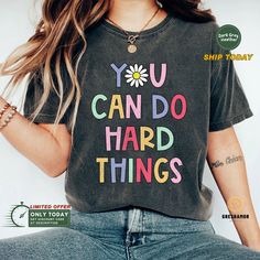 "🌟 Final Call: Christmas Orders End Dec 7! 🎄 🔥 Use code SAVEMORE at checkout for 30% OFF with 2+ item order. Don't miss out! The \"You Can Do Hard Things\" shirt is the perfect motivational and inspirational shirt for anyone who needs a boost of confidence. It's a great teaching shirt and counselor gift, as well as a gift for teachers and moms. The shirt promotes a growth mindset and encourages kindness, reminding us that we can do hard things and we can do them together. With its simple yet powerful message, this hard things shirt is sure to inspire and uplift. 📏 SHIRT MATERIAL * Super soft, light and comfortable, with the right amount of stretchy makes these short sleeve t-shirts a perfect daily garment. These are great fit for both men and women, won't shrink, and may become even so Librarian Shirt, Teaching Shirts, Pediatric Nursing, Book Shirts, Cute Sweatshirts, Inspirational Shirt, Doberman, White Ink, Personalized T Shirts