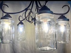 three mason jar lights hanging from a chandelier