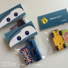 two boxes with cars in them and some candy wrappers on the bottom one has eyes