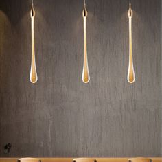 three wooden spoons hanging from the side of a wall next to two chairs and a table