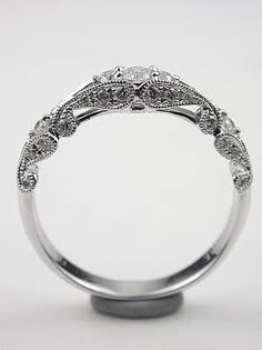 a wedding ring with an intricate design on the top and sides, set in white gold