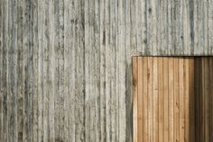 an open wooden door on the side of a building with wood slats covering it