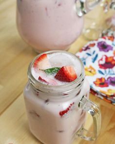 two mason jars filled with ice and strawberries