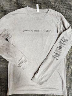 I wear my heart on my sleeve  Only, I want to add the names of your loved ones using their personal signature!! After you checkout- I will send you the details on how to send me the signatures! OR, I can add names using a similar font to the shirt.  All unisex sizing. ASH & SPORT Gray are Gildan 50/50 and JerZees 50/50.  Tultex is listed separate. Allow 2-3 days after I receive the signatures to process and ship. All items are made in a smoke free home Free shipping. *The shirt shown is not the same brand I have on hand. Casual Long Sleeve T-shirt With Custom Artwork, Heart On My Sleeve Shirt, Heart On My Sleeve, Custom Signature, Brand Me, Heart On, Home Free, 50 50, Long Sleeve Shirt