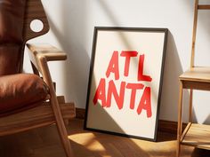 a chair sitting next to a poster with the word atl anta on it