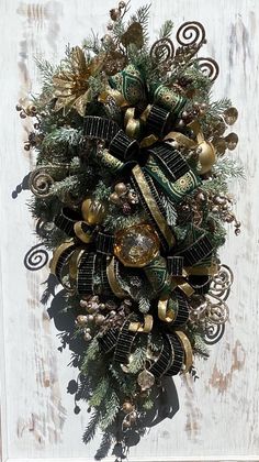 a christmas wreath hanging on the side of a door with ornaments around it and pine cones