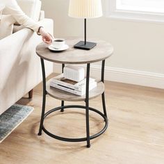 a woman sitting on a couch next to a table with a cup and saucer