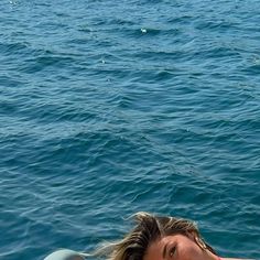 a woman laying on top of a surfboard in the ocean