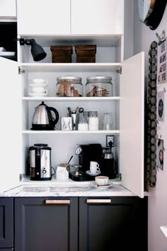 a kitchen with black cabinets and white walls