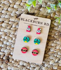 three pairs of earrings sitting on top of a woven mat