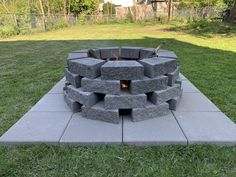 a fire pit sitting on top of a cement slab in the middle of a yard