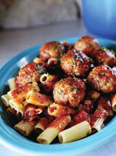 a blue bowl filled with pasta and meatballs