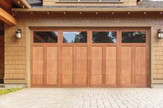 a brown garage door with two windows and brick walkway leading to the front entrance area