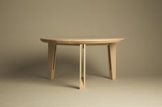 an oval wooden table with one leg bent down and the other end turned backwards, against a neutral background