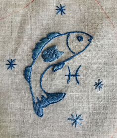 embroidered fish on linen with stars in the background