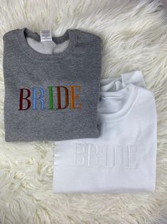 two t - shirts with the word bride printed on them, sitting on a white furnishing