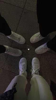 three people standing in a circle with white shoes