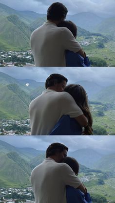 a man and woman embracing each other in front of mountains with the sky above them