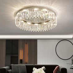 a living room with a black couch and a chandelier hanging from the ceiling