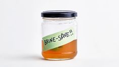 a glass jar filled with liquid and a label reading brine - save